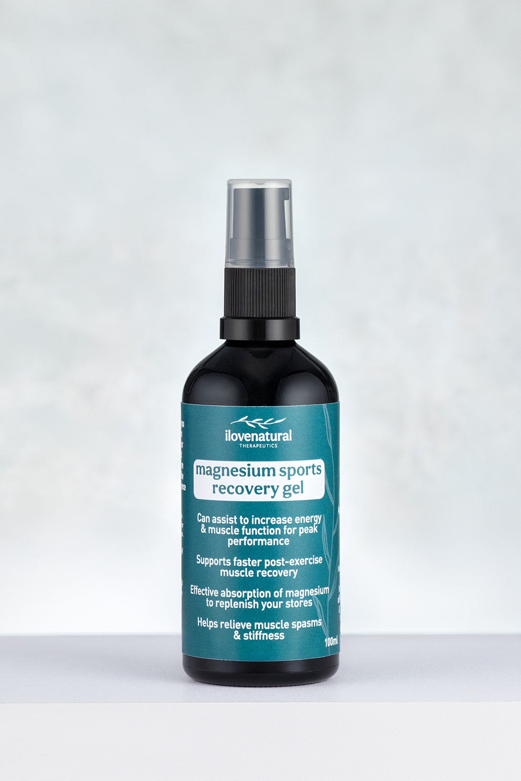 Bottle of lovenatural magnesium sports recovery gel on alight grey dappled background
